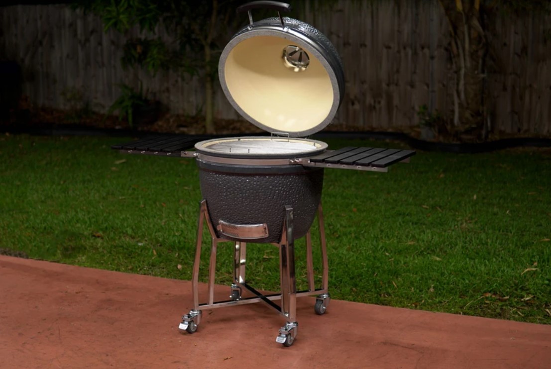This image shows an open Ceramic Kamado BBQ by SnS Grills in a back yard of an Australian home ready to cook